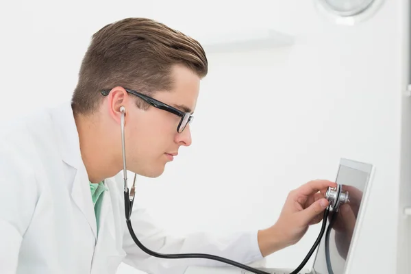 Technician listening to laptop with stethoscope — Stock Photo, Image