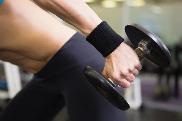 Mid section of fit woman exercising with dumbbell in gym — Stock Photo, Image