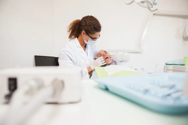 Dentista examinando los dientes de un paciente — Foto de Stock