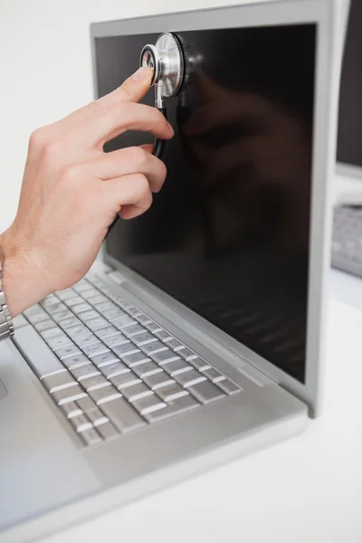 Technician listening to laptop with stethoscope — Stock Photo, Image