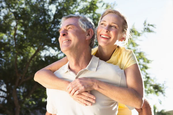 Glücklicher Senior gibt seiner Partnerin ein Huckepack zurück — Stockfoto