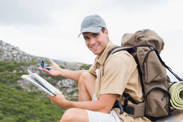 Hiking man with map on mountain terrain — Stock Photo, Image