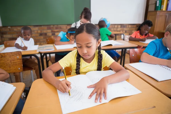 Leerlingen schrijven aan balie in klas — Stockfoto