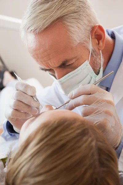 Dentista examinando los dientes de un paciente — Foto de Stock