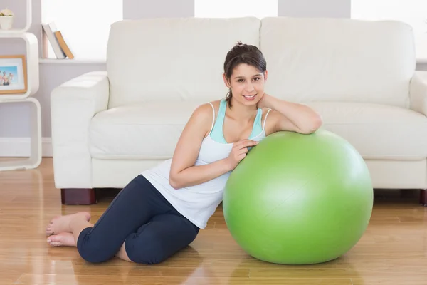 Ajuste morena apoyándose en la pelota de ejercicio — Foto de Stock