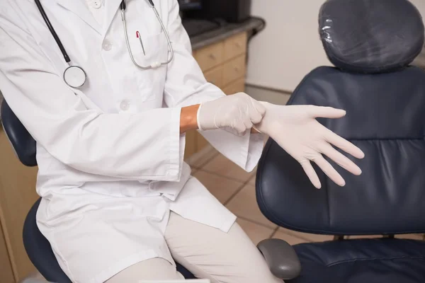 Zahnarzt zieht OP-Handschuhe an — Stockfoto