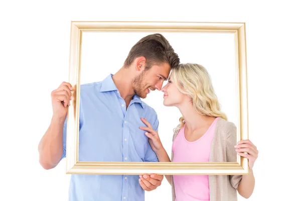 有吸引力的年轻夫妇牵着相框 — 图库照片
