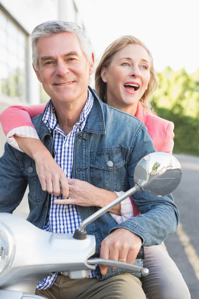Lyckliga äldre par ridning en moped — Stockfoto