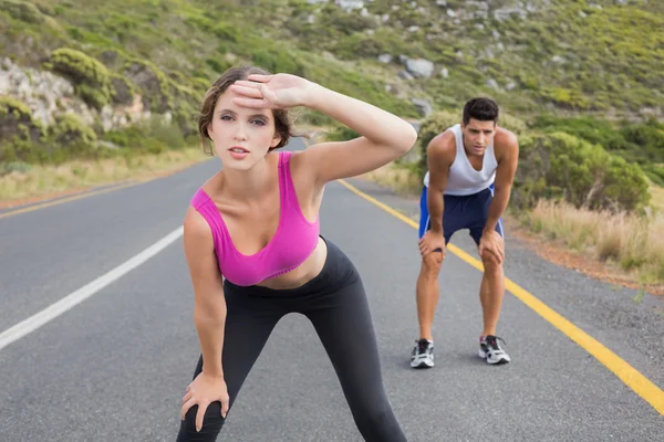 Fit jovem casal correndo na estrada — Fotografia de Stock