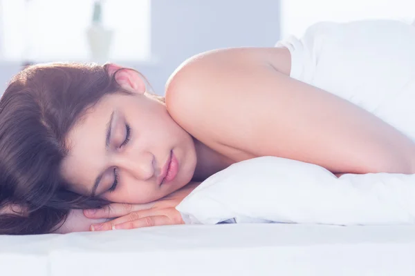 Beautiful brunette lying on bed sleeping — Stock Photo, Image