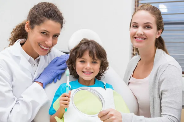 Odontólogo pediátrico que muestra al niño cómo cepillarse los dientes —  Fotos de Stock