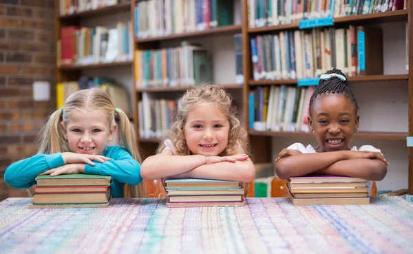 Pupilas bonitos sorrindo na biblioteca — Fotografia de Stock