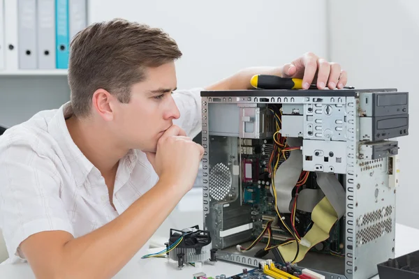 Junger Techniker arbeitet an kaputtem Computer — Stockfoto