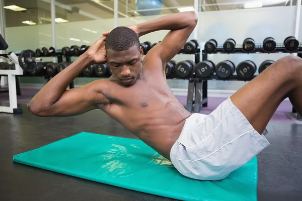 Homem fazendo crunches abdominais no ginásio — Fotografia de Stock