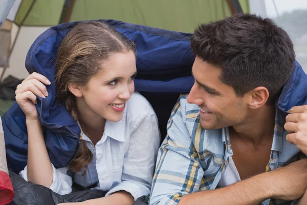 Feliz jovem casal deitado na tenda — Fotografia de Stock