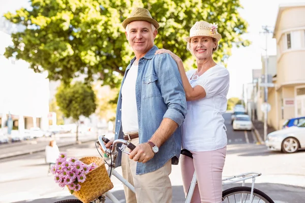 Happy mature couple going for a bike ride in the city — Stock Photo, Image