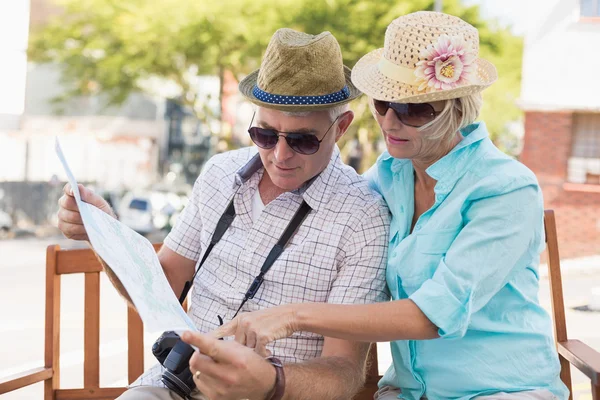 Happy tourist couple looking at map in the city — Stock Photo, Image