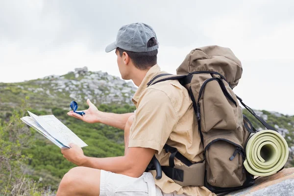 Hiking man with map on mountain terrain — Stock Photo, Image