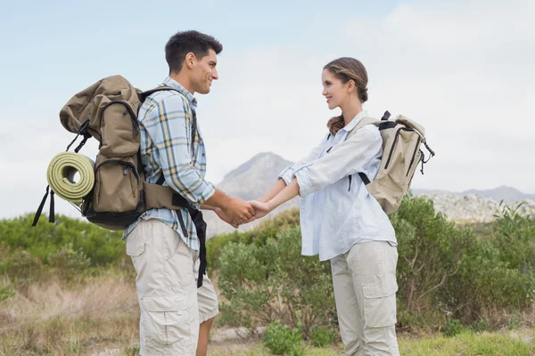 Hiking couple holding hands on mountain terrain — Stock Photo, Image