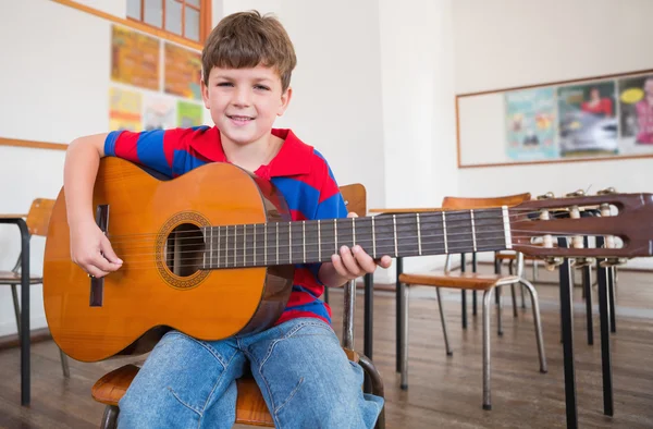 Pupil playing guitar in classroom