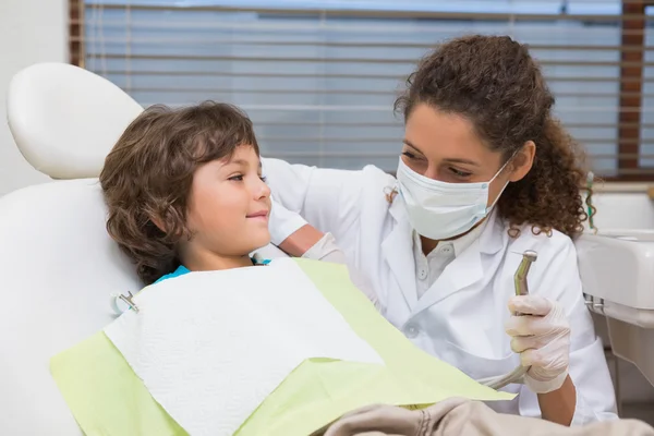 Kinderzahnarzt zeigt kleinem Jungen im Stuhl den Bohrer — Stockfoto