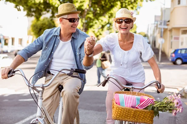 Счастливая зрелая пара собирается на велосипедную прогулку по городу — стоковое фото
