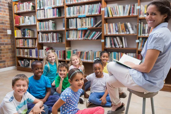 Leerlingen zittend op de vloer in bibliotheek — Stockfoto