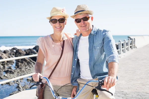 Счастливая случайная пара собирается на велосипедную прогулку по пирсу — стоковое фото