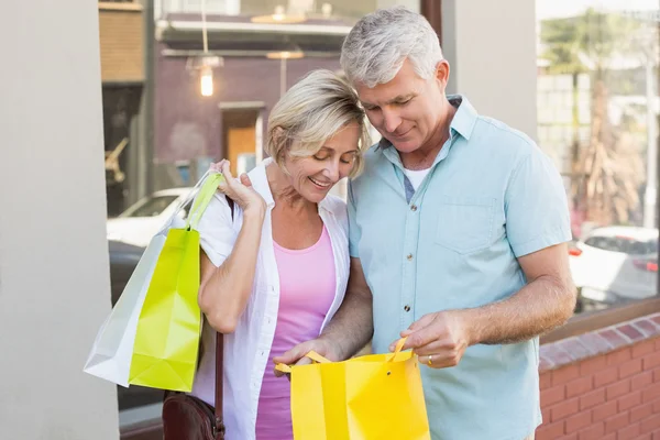 Szczęśliwa para dojrzałych, patrząc na ich zakupy zakupy — Zdjęcie stockowe