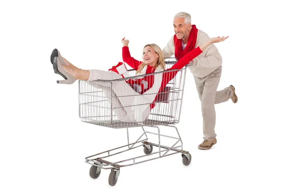 Festive couple messing about in shopping trolley — Stock Photo, Image