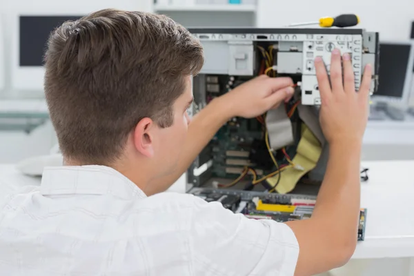 Joven técnico trabajando en una computadora rota — Foto de Stock