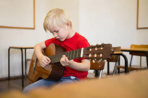 Pupil playing guitar in classroom — Stock Photo, Image