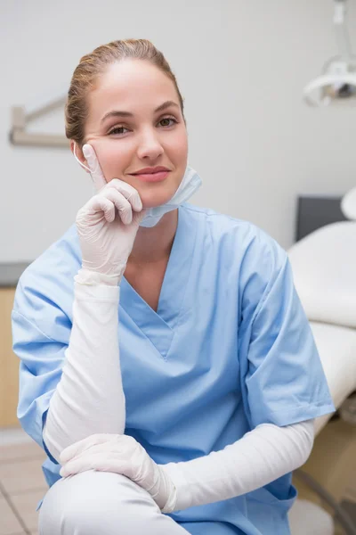 Стоматолог в синей форме улыбается в камеру — стоковое фото