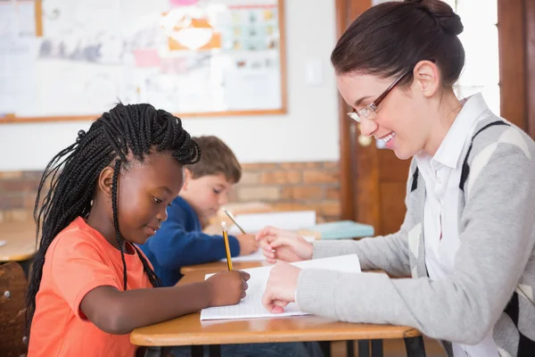 Pupil getting help from teacher in classroom — Stock Photo, Image