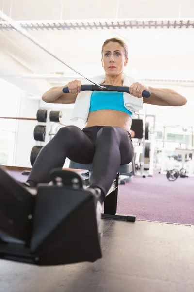 Femme travaillant sur un appareil de fitness au gymnase — Photo