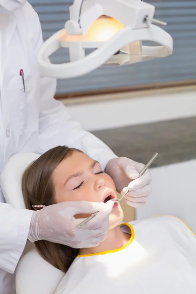 Dentista examinando los dientes de un paciente — Foto de Stock