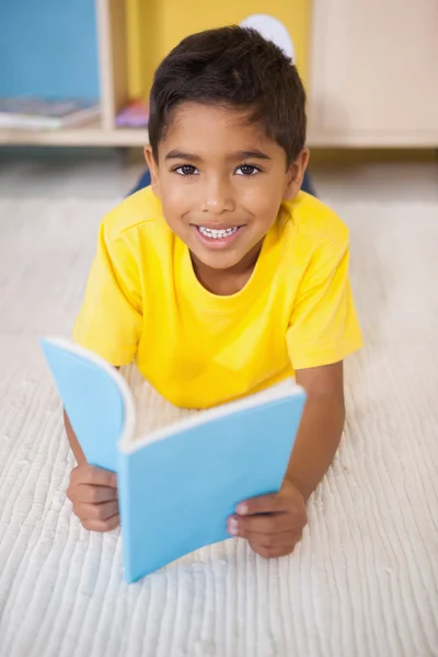 Jongen op verdieping lezen in de klas — Stockfoto