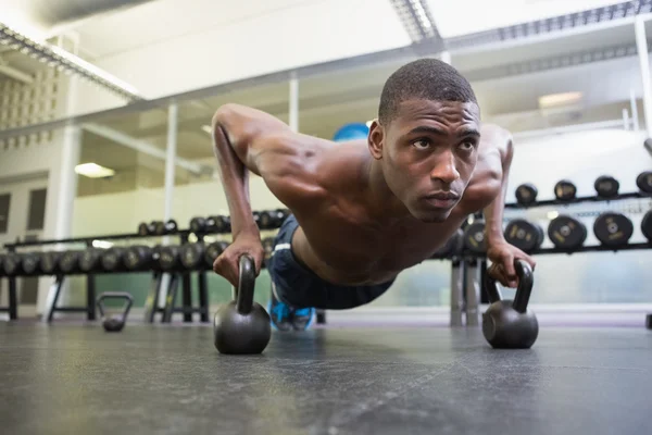 Man gör push ups med vattenkokare klockor — Stockfoto