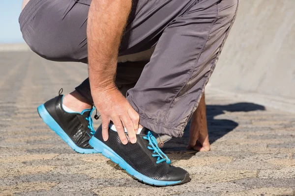 Active senior man touching his injured ankle — Stock Photo, Image