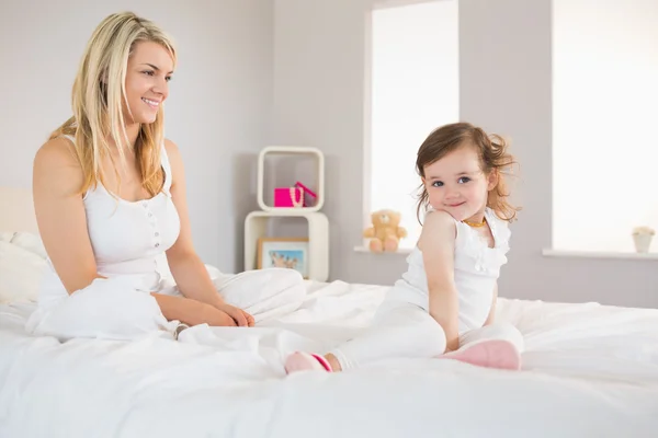 Moeder en dochter zittend op bed thuis — Stockfoto