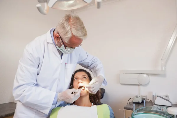 Dentista examinando los dientes de un paciente — Foto de Stock