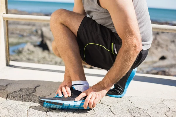 Fit man gripping his injured ankle — Stock Photo, Image