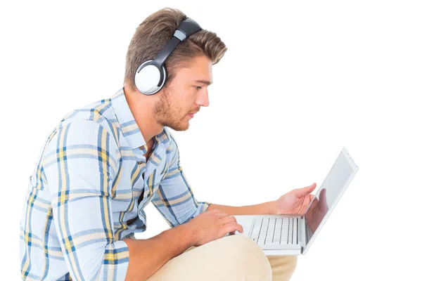 Schöner junger Mann sitzt mit Laptop — Stockfoto