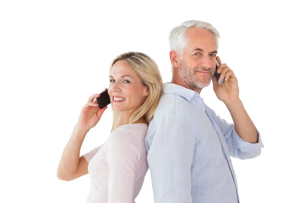 Pareja feliz hablando en sus teléfonos inteligentes — Foto de Stock