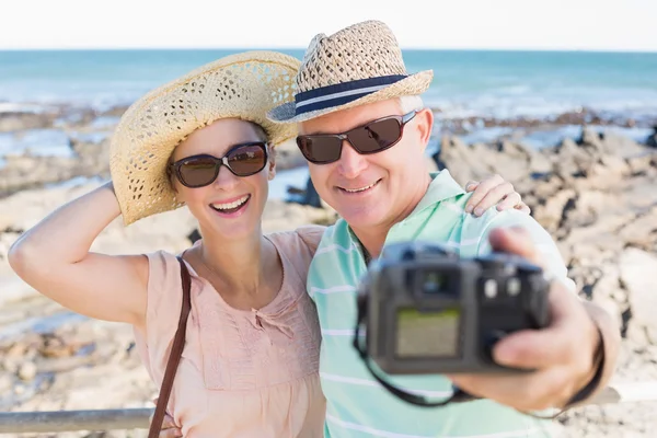 Feliz pareja casual tomando una selfie por la costa — Foto de Stock