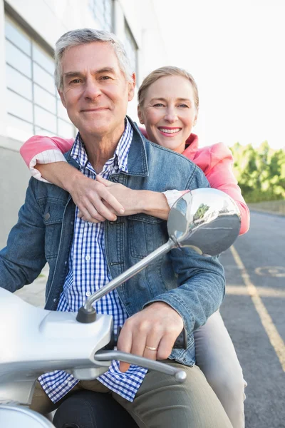 Happy senior couple riding a moped — Stock Photo, Image