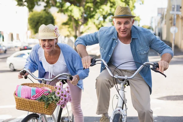 Happy mature couple going for a bike ride in the city — Stock Photo, Image