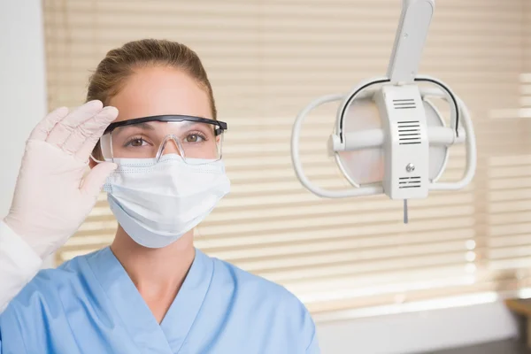 Стоматолог в хирургической маске и защитных очках — стоковое фото
