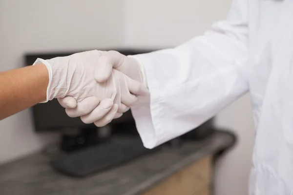 Dentista estrechando la mano con su paciente — Foto de Stock