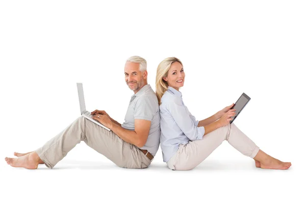 Couple heureux assis en utilisant ordinateur portable et tablette PC — Photo